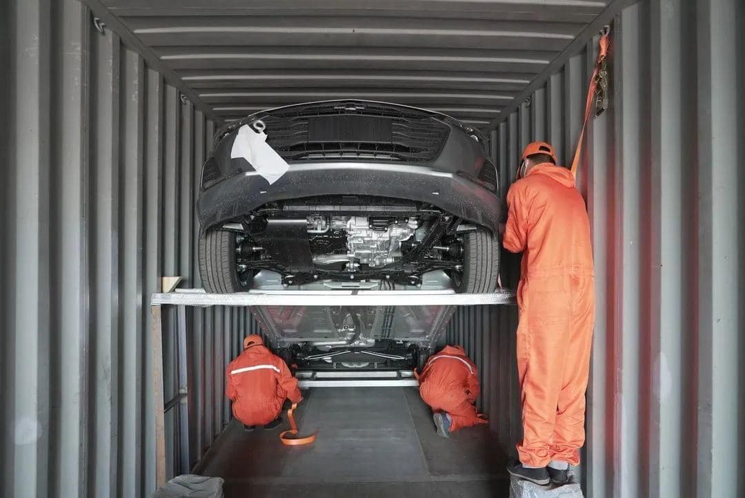Vehicles secured on a two-tier rack inside a shipping container